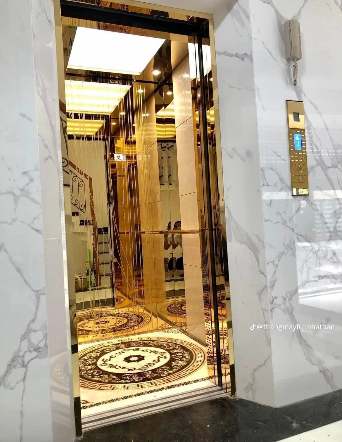 Open luxury gold elevator with marble floor medallion
